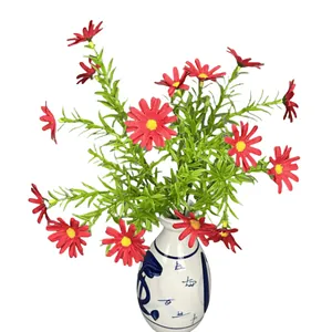 Artificial red daisy bouquet with fifteen heads in a blue and white ceramic vase