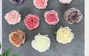 Dettaglio di testine di peonie e rose artificiali multicolore su sfondo grigio scuro