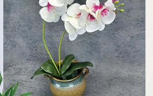 Detail of white PU orchid petals with purple centers in a textured ceramic pot