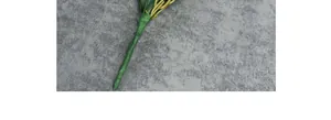 Detalle de tallos de orquídea artificiales en 3D envueltos en cinta floral verde y tela