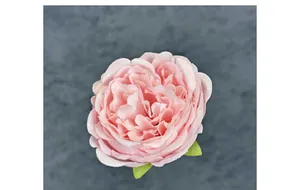 Macro di una testa di peonia artificiale rosa con foglie verdi per decorazioni nuziali