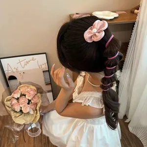 Pink floral hair clip and spiral hair ties set shown on model for elegant hairstyling