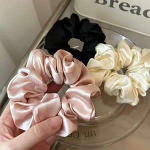 Glossy satin scrunchie set in pink, white, and black with a premium silk luster texture