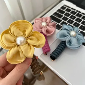 Floral spiral hair clip with satin petals and pearl detail in yellow pink and blue