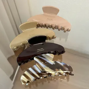 Close-up of four assorted acetate hair claw clips with elegant glossy marble patterns