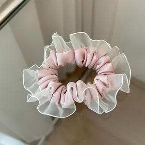 Detalle de coletero de satén rosa con ribete de encaje de organza blanca en fondo pulido