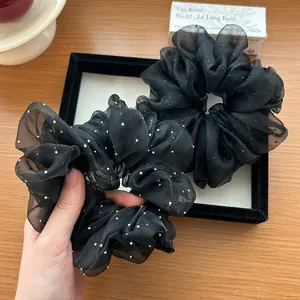 Macro shot of large black organza scrunchie featuring white crystal polka dot accents