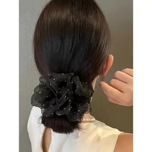 Elegant oversized black organza scrunchie with white pearl embellishments on a hair bun
