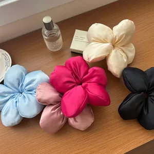 Détails de cinq chouchous fleurs en satin de soie aux couleurs pastel assorties