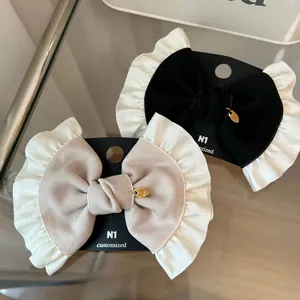 Detail of French retro ribbon bow hair clips with lace trim on a branded display card
