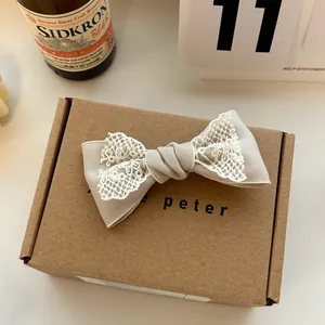 Detailed view of French vintage lace bow hair clip on a natural brown gift box