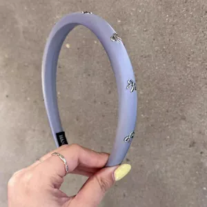 Serre-tête en tissu violet clair avec des décorations de nœuds en métal argenté