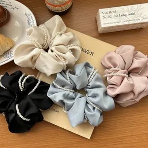Elegant satin hair scrunchies with pearls in cream, blue, black, and pink colors