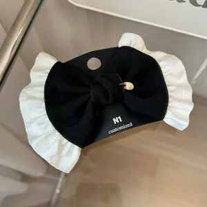 Detail of French vintage bow hair clip with lace trim and small gold metal pendant