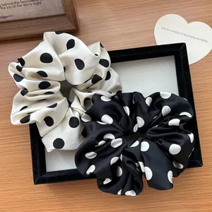 Set di elastici per capelli a pois in raso bianco e nero su vassoio elegante