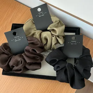 Three-piece satin scrunchie set in olive green, dark brown, and black colors