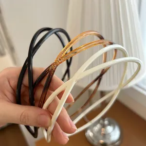 Détail de serre-têtes doubles antidérapants en noir, ambre et beige sur fond doux