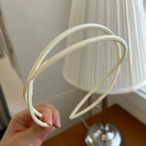 Détail d'un serre-tête double épaisseur blanc crème avec dents intérieures fines
