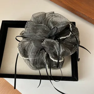 Detail of grey organza striped scrunchie with faux pearls and black silk ribbon tie