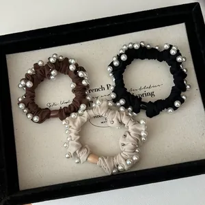Three-piece pearl elastic hair ties set in brown, black, and beige matte fabric