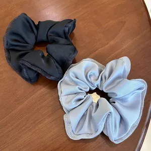 Detail of black and light blue satin scrunchies with elegant organza lace edges