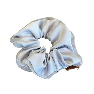 Elegant silver-grey satin and mesh scrunchie with layered fabric design on white background