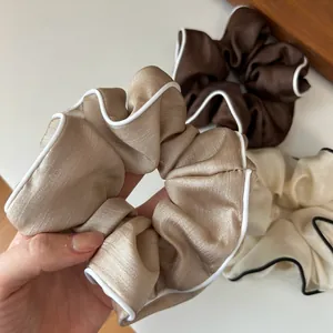 Gros plan de chouchous en satin de haute qualité avec bordure contrastée élégante