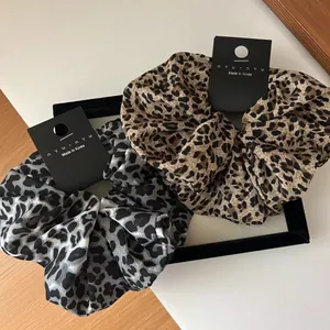 Close-up of leopard print oversized scrunchies in brown and grey fabric texture