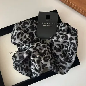 Detail of satin leopard print hair scrunchie with nyu.nyu tag and made in Korea label