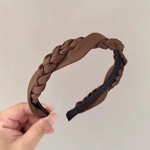 Vue détaillée du serre-tête tressé en satin marron montrant la texture du tissu soyeux