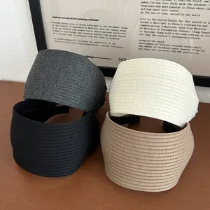 Detail of wide pleated headbands in grey black beige and brown colors on wood