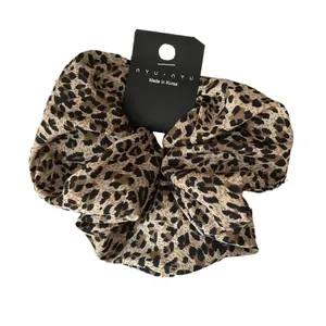 Retro oversized leopard print fabric scrunchie with nyu nyu tag on white background