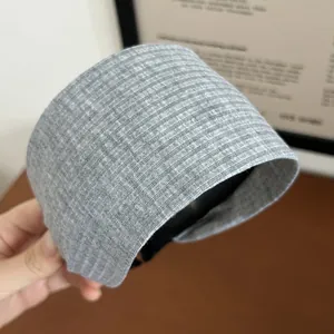 Close-up of light grey wide knitted headband with detailed vertical ribbing texture