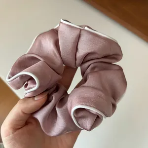 Chouchou en satin mauve élégant avec bordure blanche et texture soyeuse et lisse
