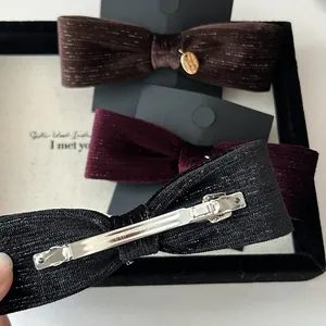 Detail of velvet bow hair clips in brown, burgundy, and black with metal spring clips