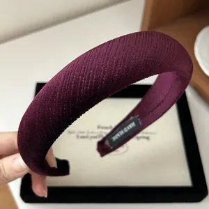 Detailed texture of burgundy pleated velvet headband with handmade inner label