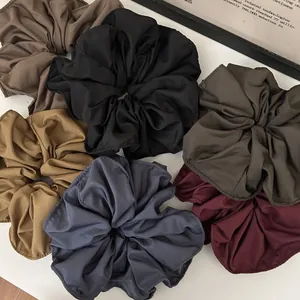 Detailed set of six large fabric scrunchies in diverse solid colors with pleated texture