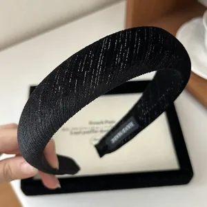 Detailed shot of handmade black velvet headband with silver glitter and ribbed texture