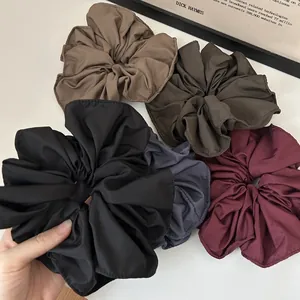 Set of five large pleated fabric scrunchies in classic black, brown, and wine red tones