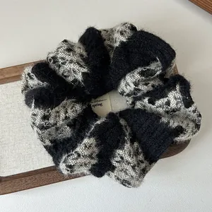 Close-up of a soft knitted scrunchie with spring tag on a wooden display tray
