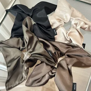 Elegant satin scarf scrunchies with long ribbons in black and gold silky fabric