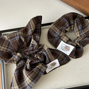 Detail of vintage brown plaid scrunchie and headband with cute bear fabric label