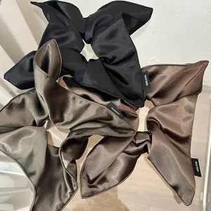 Detailed view of handmade silk satin hair scrunchies in black, brown and khaki