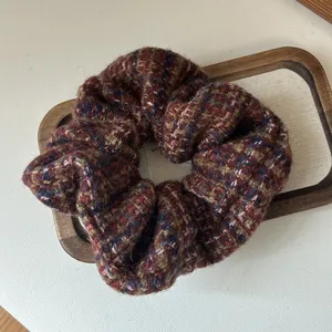 Close-up of thick tweed plaid scrunchie with classic wine red and navy knit texture