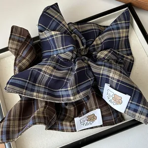 Detailed close-up of navy and brown plaid scrunchies with cute bear fabric labels