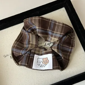 Macro detail of vintage plaid scrunchie with cute cartoon animal woven label