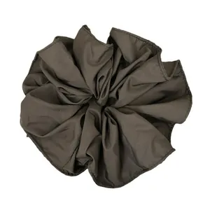 Deep brown oversized scrunchie with layered ruffle trim and smooth matte fabric texture