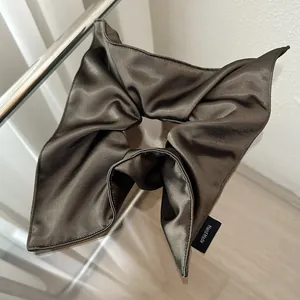 Close-up of a handmade dark brown satin bow hairband with a premium silky texture