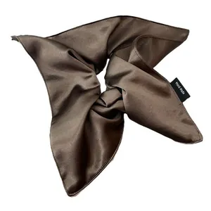 Deep coffee satin scrunchie with handmade label and silky texture on white background