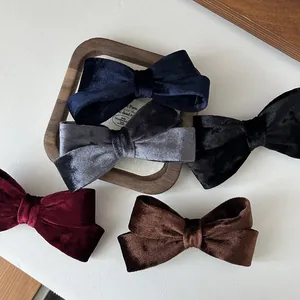 Cinque fermagli per capelli in velluto in vari colori su vassoio in legno elegante